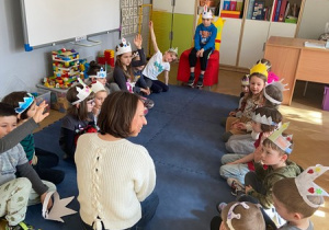 Dzieci w koronach siedzą na dywanie